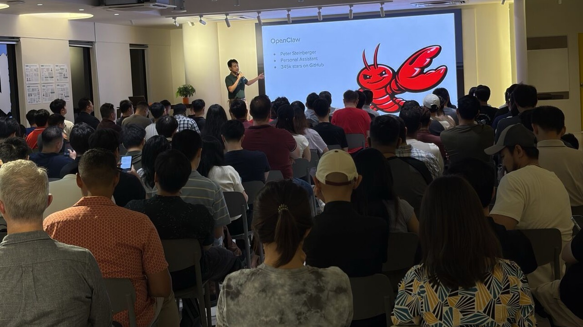 Speaker beside an OpenClaw overview screen facing a seated audience