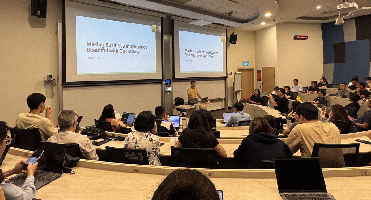 Speaker and lecture audience beneath business intelligence title screens