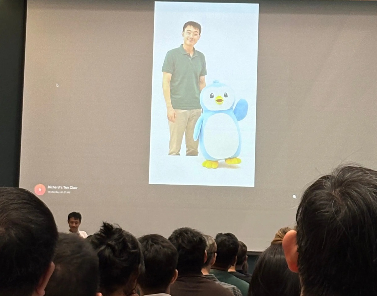 Audience watching a screen showing a generated man and penguin at the Tencent Cloud event